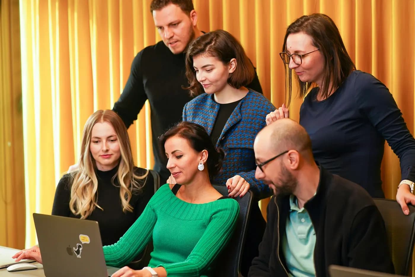 Een commissie kijkt samen naar een laptop