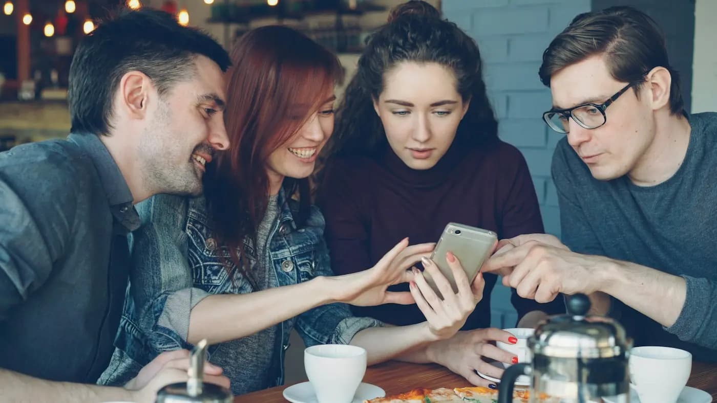 Vrienden kijken samen naar foto's op een telefoon