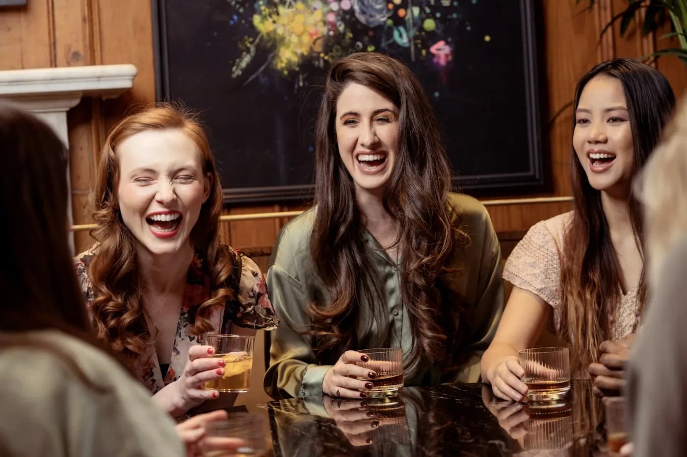 Drie vriendinnen lachen samen met een drankje