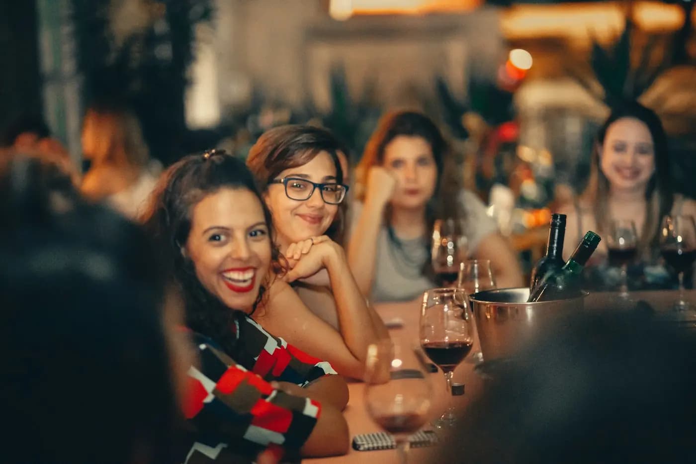 Drie vriendinnen lachen aan een lange tafel