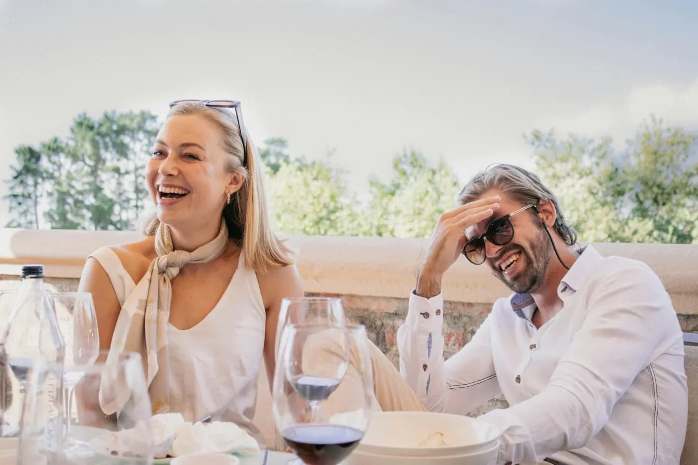 Een man en een vrouw lachen samen aan tafel