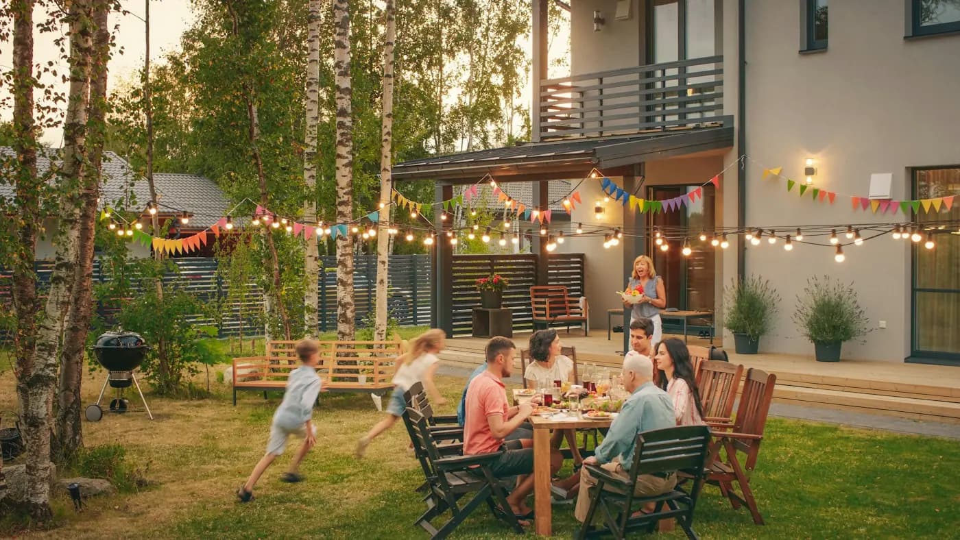 Vrienden eten samen aan een lange tafel in de tuin