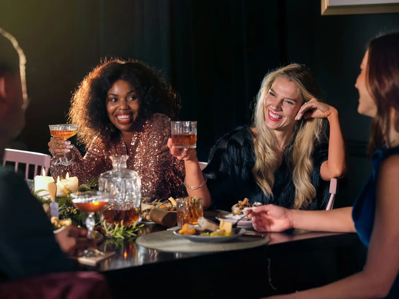 Vriendinnen proosten lachend aan een gedekte tafel