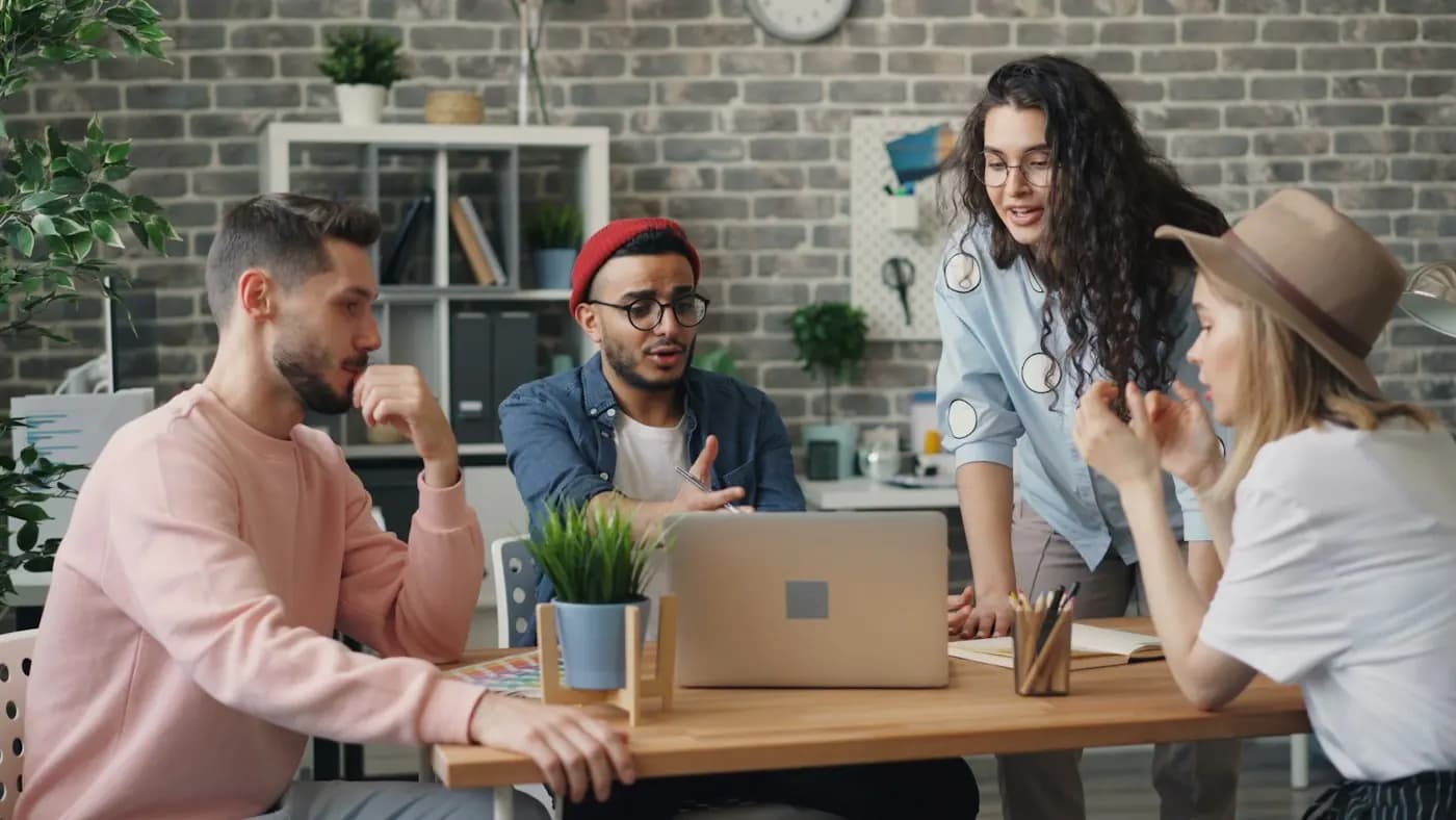 Een commissie overlegt rond een laptop aan tafel